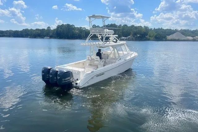 Slide: The Image of 2011 Everglades 350LX boat on a calm lake under a blue sky. - 8