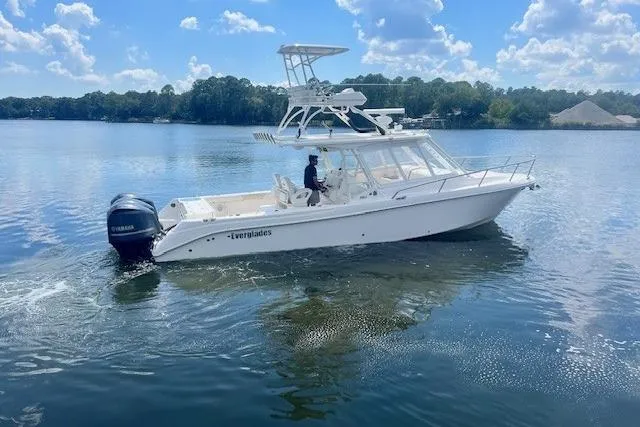 Slide: The Image of 2011 Everglades 350LX boat cruising on a serene lake under a blue sky. - 9