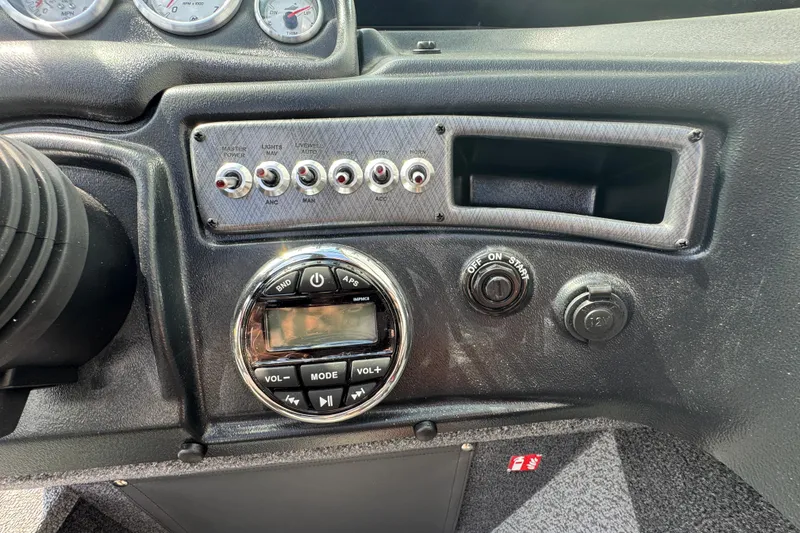 Slide: The Image of Dashboard controls of 2026 Lund 1875 Fisherman boat, featuring switches and audio system. - 12