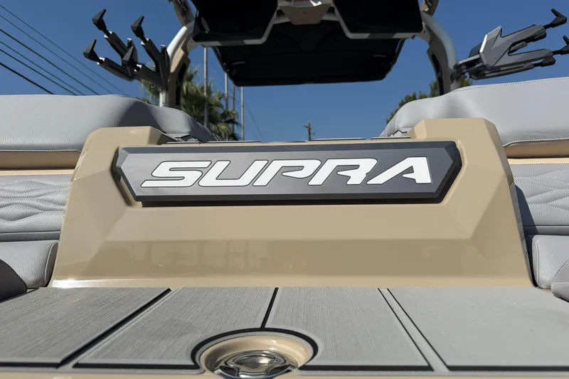 Slide: The Image of 2026 Supra SL 450 boat, rear view with logo, beige and gray seating. - 16