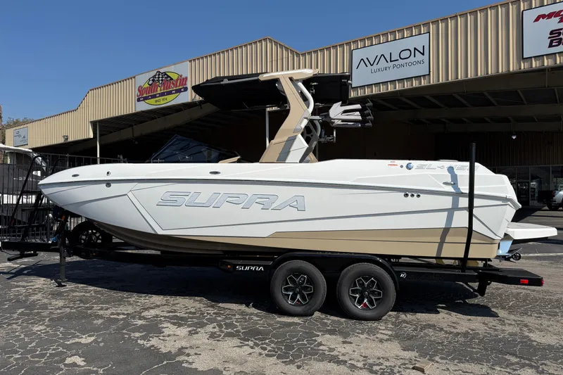 Slide: The Image of 2026 Supra SL 450 boat on trailer outside dealership, showcasing sleek design and modern features. - 3