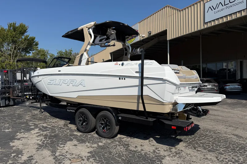 Slide: The Image of 2026 Supra SL 450 boat on trailer outside luxury pontoon dealership. - 4