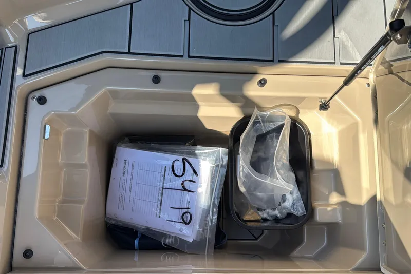 Slide: The Image of Storage compartment of 2026 Supra SL 450 boat with documents and bags inside. - 44
