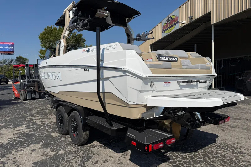 Slide: The Image of 2026 Supra SL 450 boat on trailer, white and beige design, parked outdoors. - 5