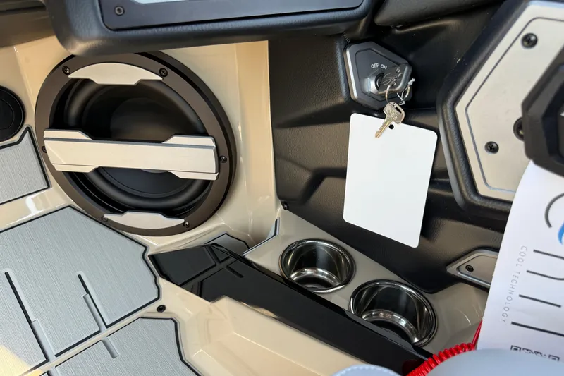 Slide: The Image of Interior of 2026 Supra SL 450 with speaker, ignition keys, and cup holders. - 62