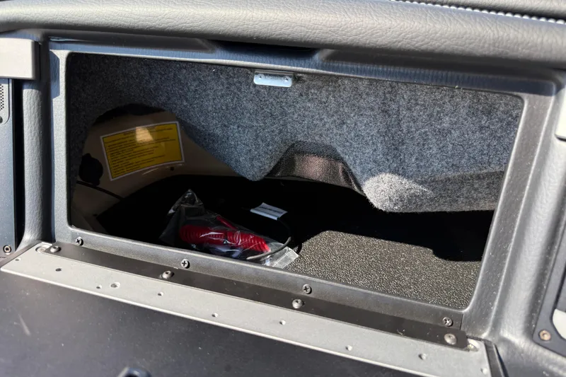 Slide: The Image of 2026 Supra SL 450 glove compartment interior with storage space and manual. - 64