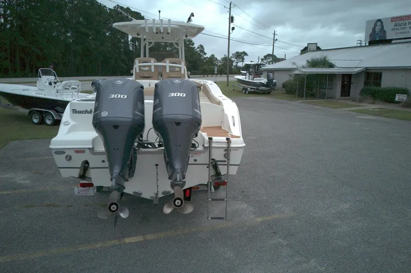 Slide: The Image of 2019 NauticStar 28 XS boat with dual 300 horsepower engines in a parking lot. - 12