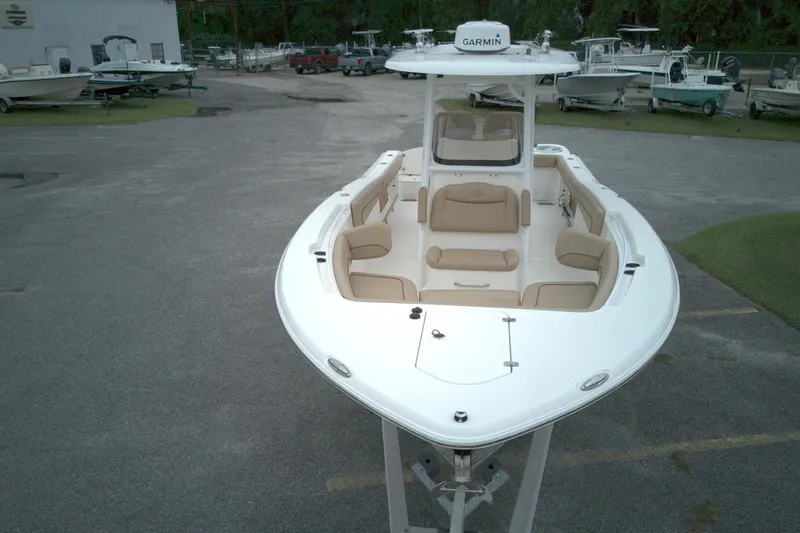 Slide: The Image of 2019 NauticStar 28 XS boat with tan seating, parked in a marina. - 14