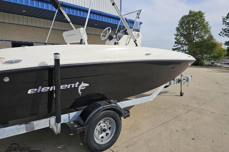 Slide: The Image of 2016 Bayliner Element F18 boat on trailer, parked outdoors near a building. - 13