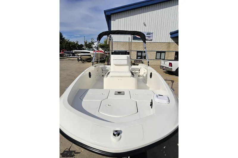 Slide: The Image of 2016 Bayliner Element F18 boat with open deck, parked outdoors near a building. - 21