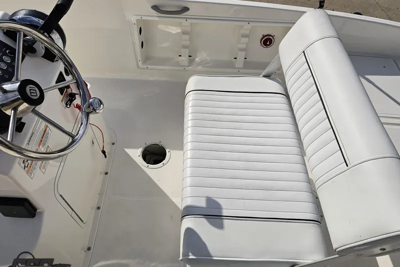 Slide: The Image of 2016 Bayliner Element F18 boat interior with white seating and steering wheel. - 61