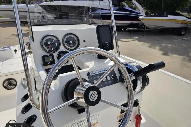 Slide: The Image of 2016 Bayliner Element F18 boat dashboard with steering wheel and gauges. - 62