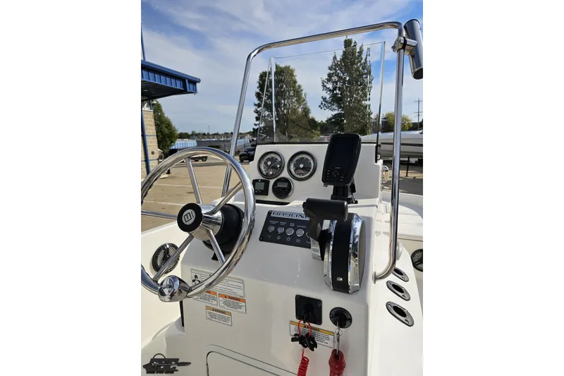 Slide: The Image of 2016 Bayliner Element F18 boat console with steering wheel and controls. - 66