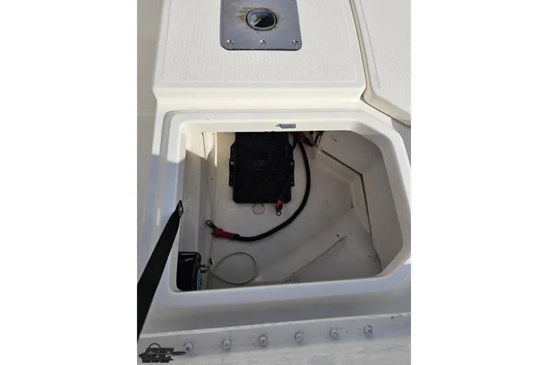 Slide: The Image of 2016 Bayliner Element F18 boat storage compartment with battery and wiring. - 80