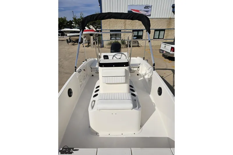 Slide: The Image of 2016 Bayliner Element F18 boat with seating and canopy, displayed outdoors. - 82