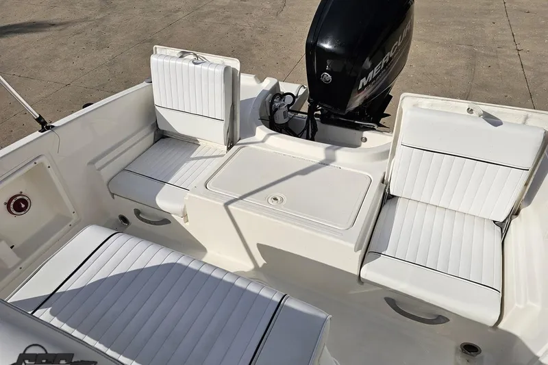 Slide: The Image of 2016 Bayliner Element F18 boat interior with white cushioned seating and Mercury outboard motor. - 87