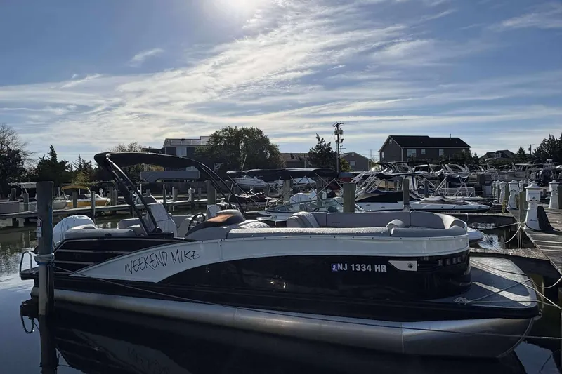 The Image of 2021 Bennington 27RX pontoon boat docked at marina under clear sky. - 1