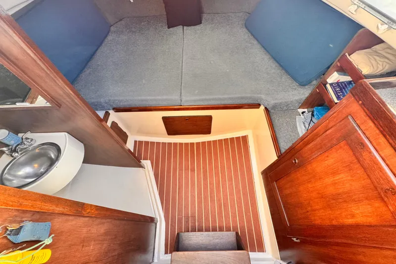 Slide: The Image of 1979 O'Day 37 Center Cockpit interior with wooden cabinetry and compact sink. - 13