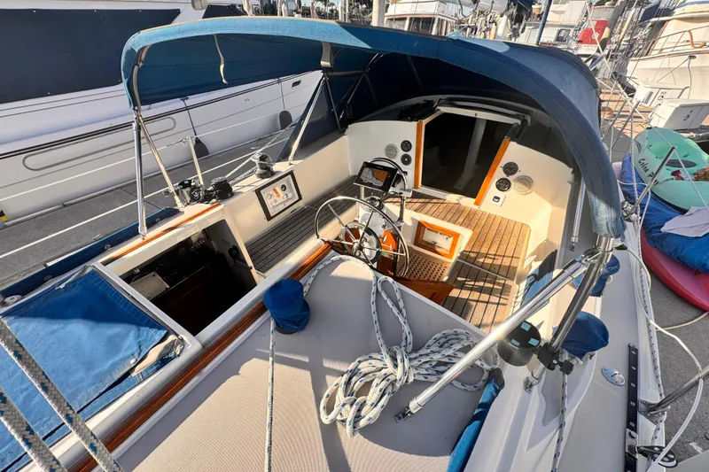 Slide: The Image of 1979 O'Day 37 Center Cockpit sailboat with blue canopy and wooden deck details. - 16