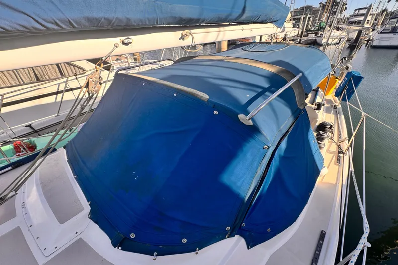 Slide: The Image of 1979 O'Day 37 Center Cockpit sailboat with blue canvas cover in marina. - 25