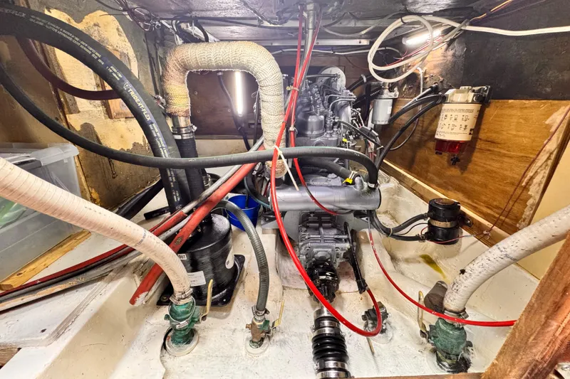 Slide: The Image of Engine compartment of a 1979 O'Day 37 Center Cockpit sailboat, showing hoses and components. - 27