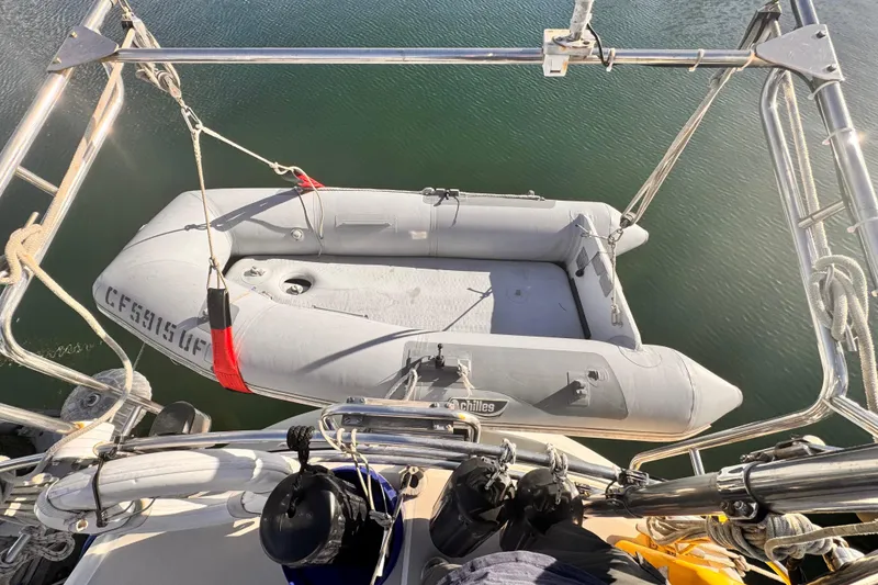 Slide: The Image of Inflatable dinghy suspended from 1979 O'Day 37 Center Cockpit sailboat over water. - 30