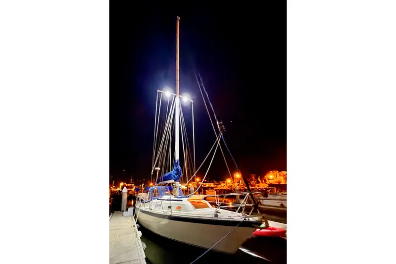 Slide: The Image of 1979 O'Day 37 Center Cockpit sailboat docked at night, illuminated by bright lights. - 39