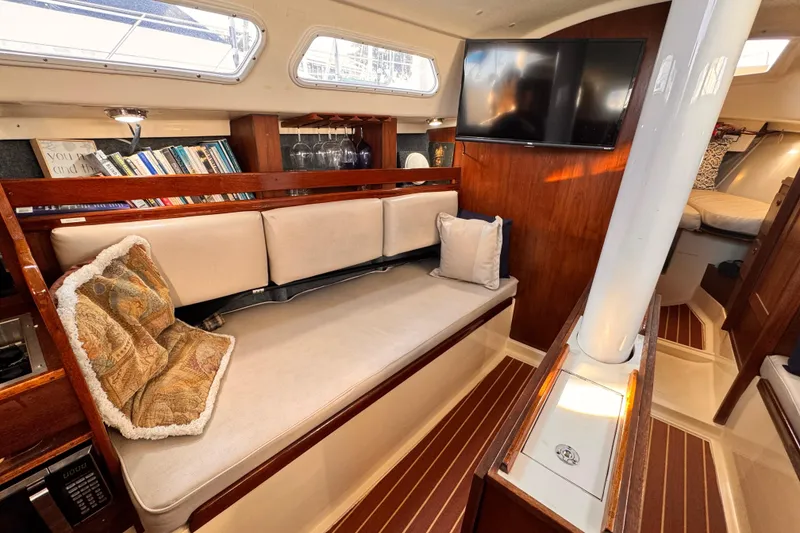 Slide: The Image of 1979 O'Day 37 Center Cockpit interior with cozy seating, bookshelves, and mounted TV. - 5