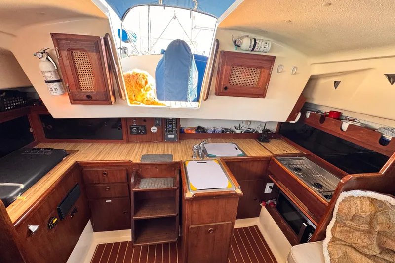 Slide: The Image of 1979 O'Day 37 Center Cockpit interior with wooden cabinetry and kitchen area. - 6