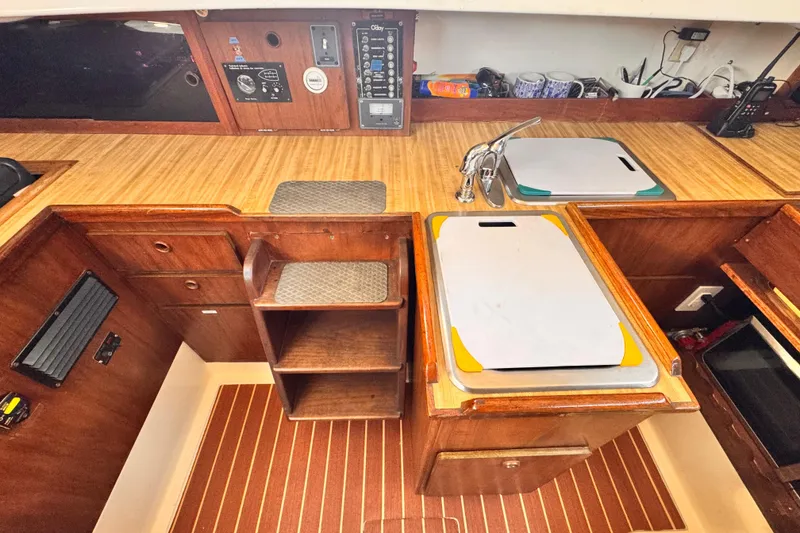 Slide: The Image of 1979 O'Day 37 Center Cockpit interior with wooden cabinetry and kitchen sink. - 8