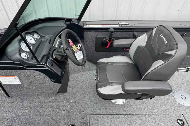 Slide: The Image of 2026 Lund 2075 Fisherman boat interior with steering wheel and cushioned seat. - 6