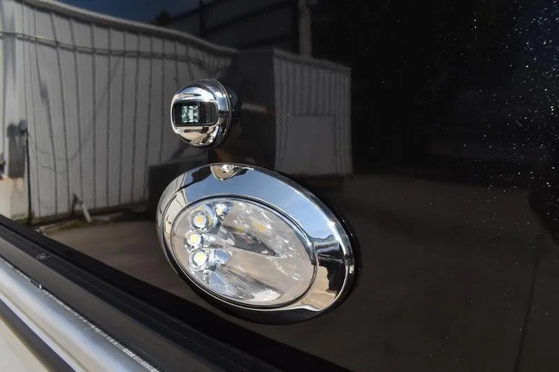 Slide: The Image of 2026 Lowe LS 170 pontoon boat with canopy on trailer, parked outdoors. - 1