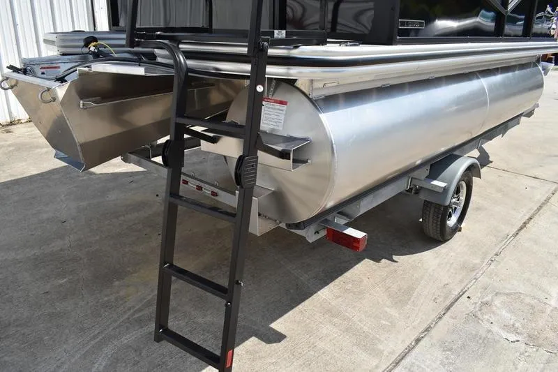 Slide: The Image of 2026 Lowe LS 170 pontoon boat on trailer, black exterior, parked outdoors. - 7