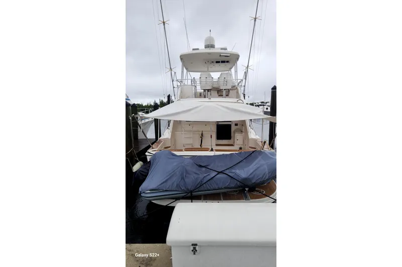 Slide: The Image of 2006 Riviera 47 Open Flybridge Series II yacht docked, rear view with covered equipment. - 14