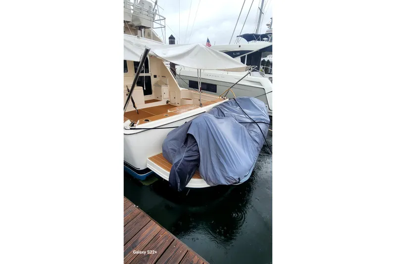 Slide: The Image of 2006 Riviera 47 Open Flybridge Series II docked, covered, with wooden deck visible. - 15