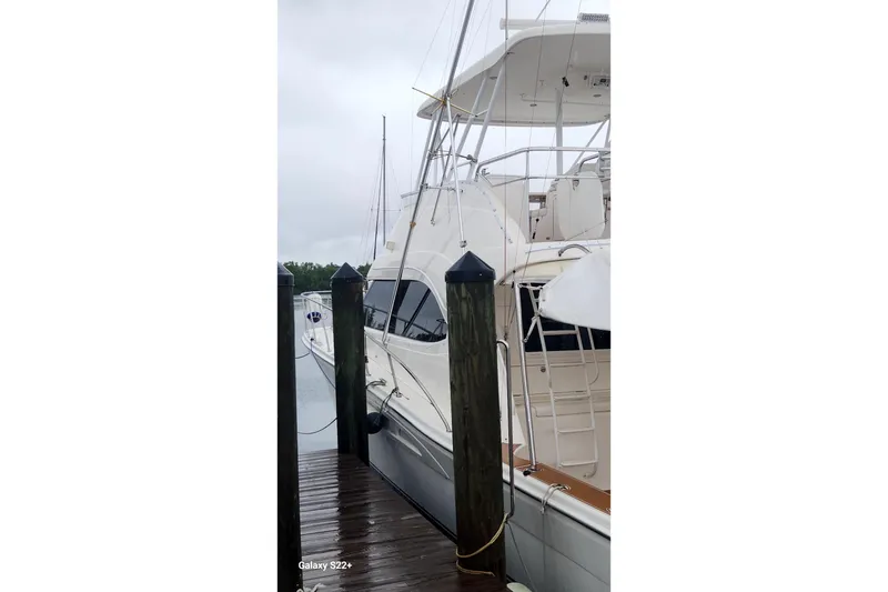 Slide: The Image of 2006 Riviera 47 Open Flybridge Series II yacht docked on a rainy day. - 17