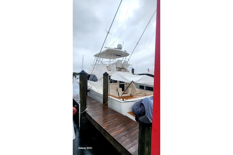 Slide: The Image of 2006 Riviera 47 Open Flybridge Series II yacht docked on a rainy day. - 23