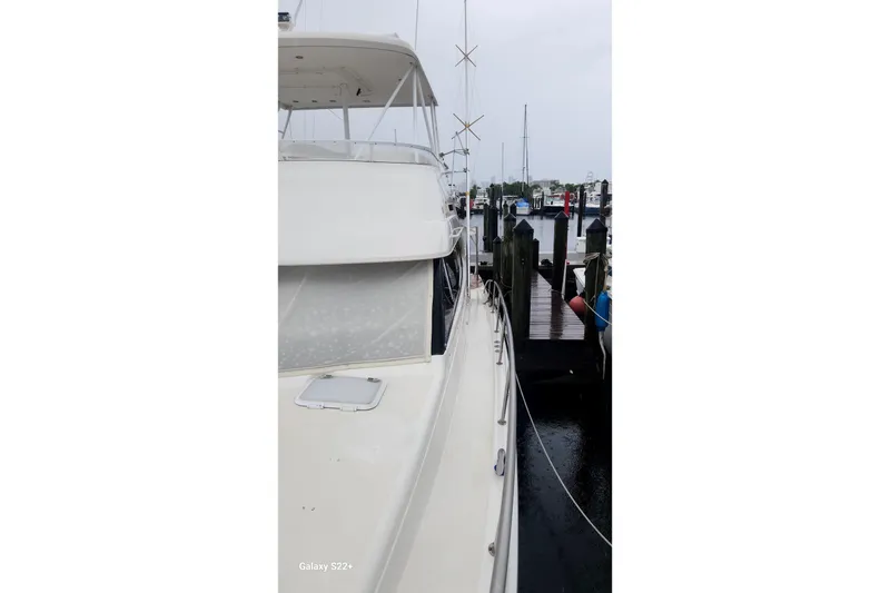 Slide: The Image of 2006 Riviera 47 Open Flybridge Series II docked at a marina on a cloudy day. - 26