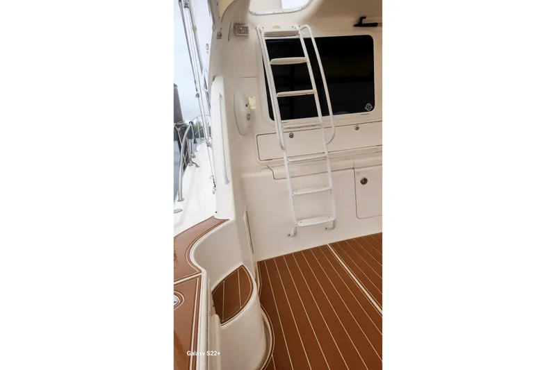 Slide: The Image of 2006 Riviera 47 Open Flybridge Series II interior with ladder and teak flooring. - 28