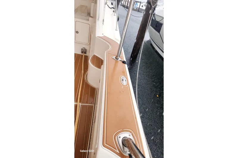 Slide: The Image of 2006 Riviera 47 Open Flybridge Series II boat deck with wood accents and railing. - 33