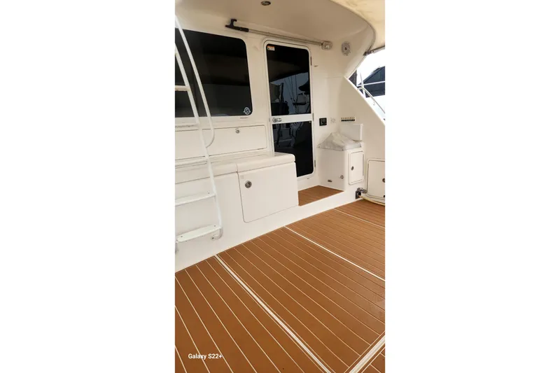 Slide: The Image of 2006 Riviera 47 Open Flybridge Series II yacht deck with ladder and seating area. - 34
