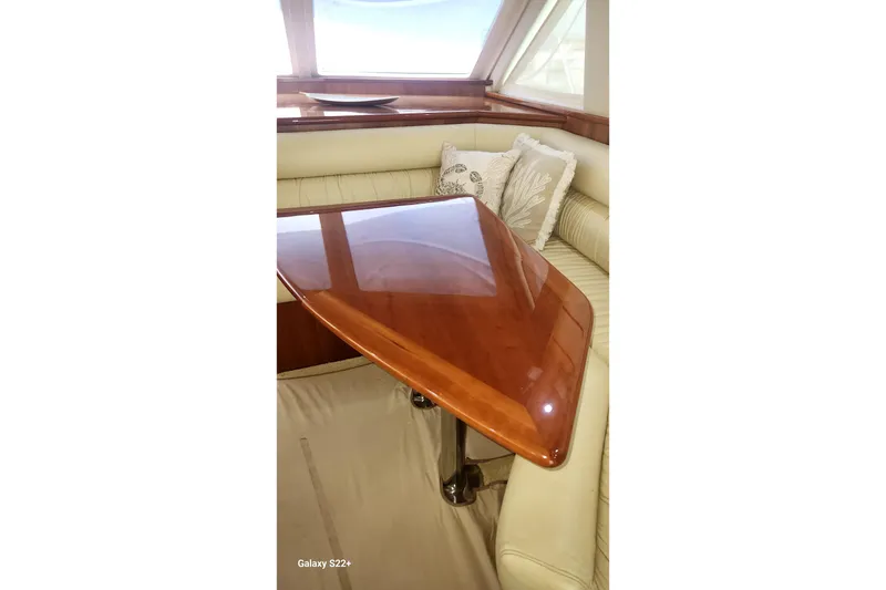 Slide: The Image of Luxurious interior of 2006 Riviera 47 Open Flybridge Series II with polished wooden table. - 40