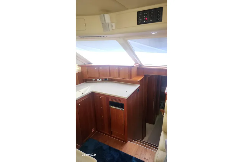 Slide: The Image of Interior of 2006 Riviera 47 Open Flybridge Series II yacht, featuring wooden cabinetry and modern design. - 44