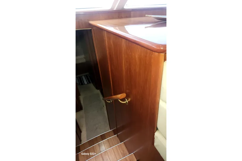 Slide: The Image of Interior view of 2006 Riviera 47 Open Flybridge Series II, featuring wooden cabinetry and stairs. - 45