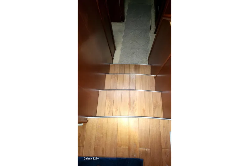 Slide: The Image of Wooden steps inside a 2006 Riviera 47 Open Flybridge Series II yacht. - 52