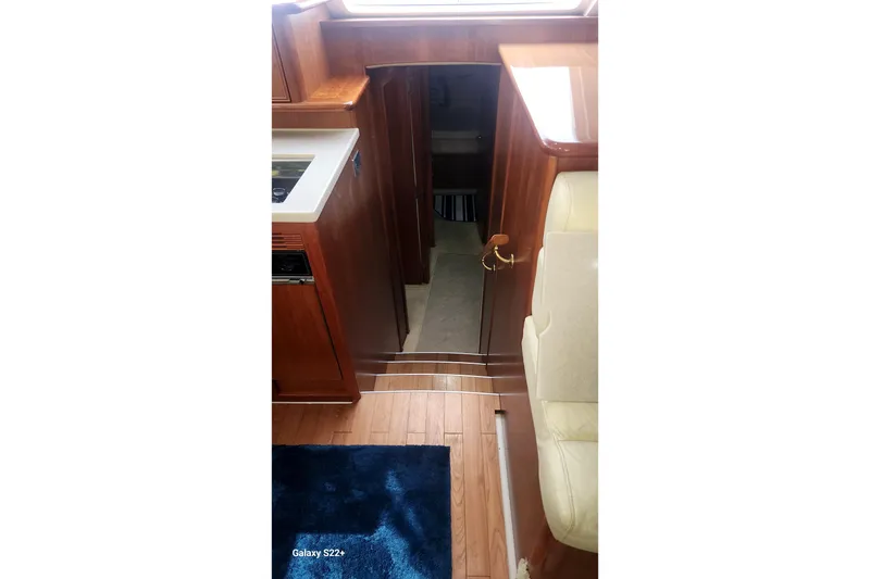 Slide: The Image of Interior of 2006 Riviera 47 Open Flybridge Series II yacht, featuring wooden cabinetry and seating. - 53