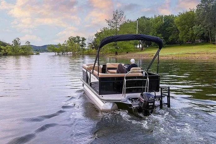 Slide: The Image of 2026 Lowe LS 170 pontoon boat cruising on a scenic lake at sunset. - 2