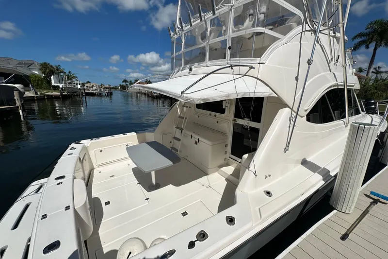 Slide: The Image of Riviera 40 Flybridge 2002 yacht docked, featuring spacious deck and flybridge under clear skies. - 12