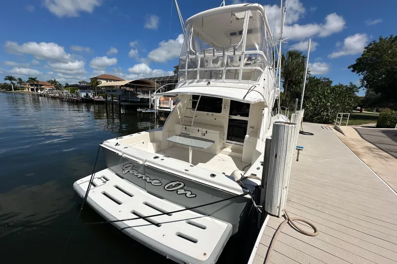 Slide: The Image of 2002 Riviera 40 Flybridge yacht docked under a clear blue sky. - 13