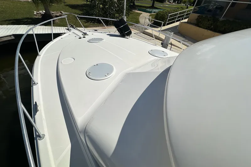 Slide: The Image of 2002 Riviera 40 Flybridge yacht deck with railing, docked near greenery. - 19